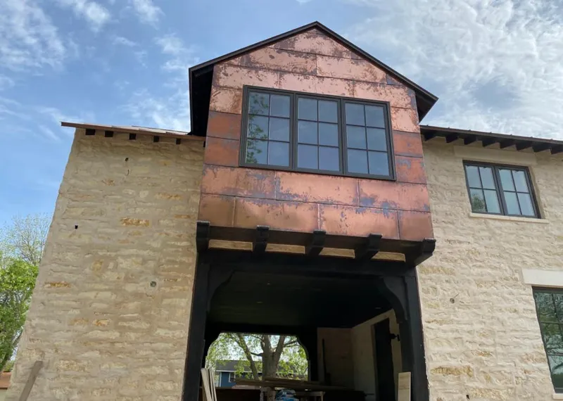 Copper metal panel facade on a stone building for Metal Roof Coating in Raymond